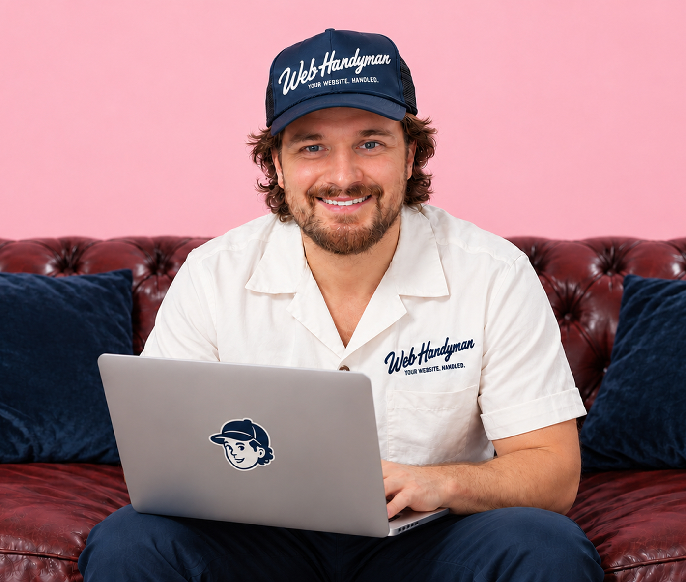 Wes Asbell sitting on a leather sofa with a laptop